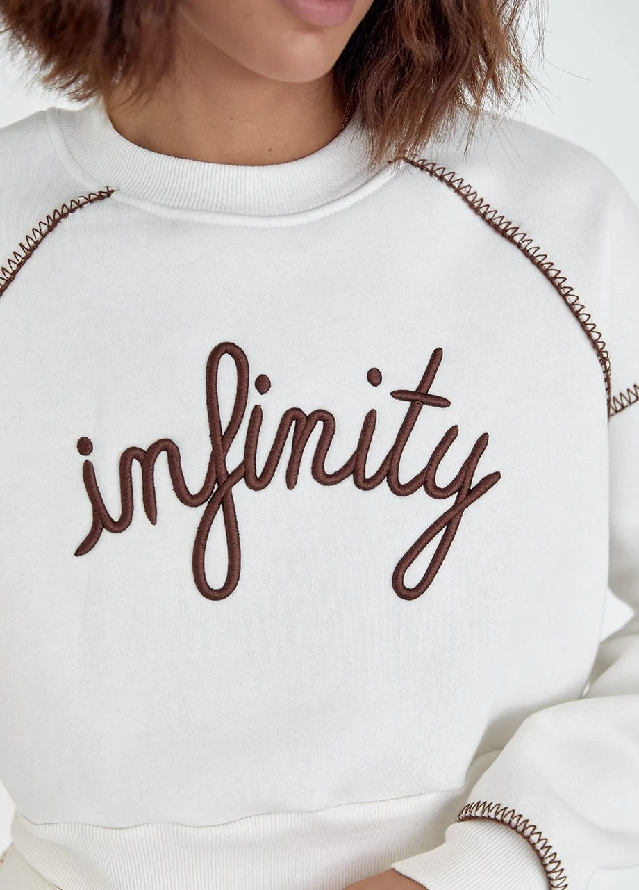 Молочний короткий утеплений світшот з вишитим написом infinity - молочний Lurex (264559067)