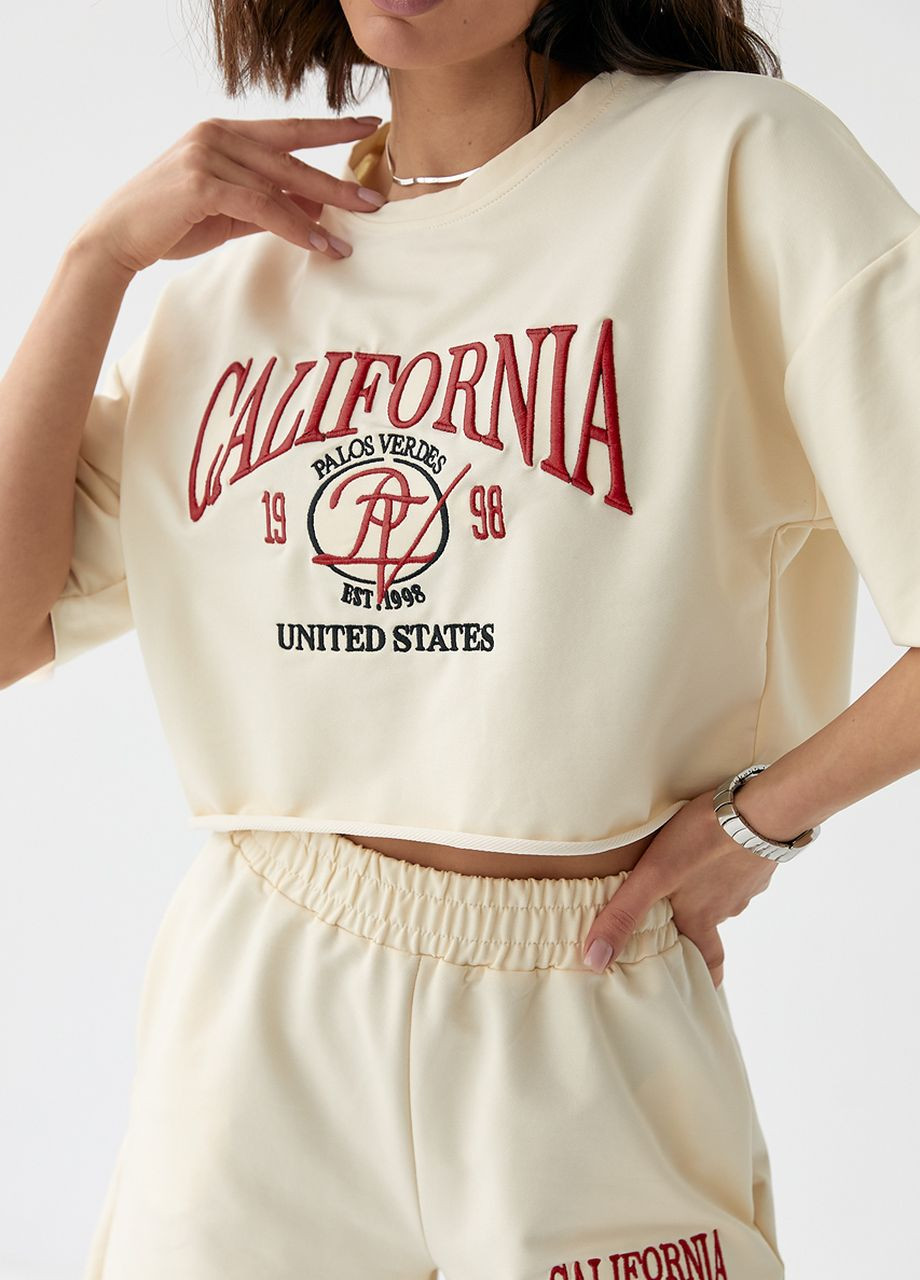 Костюм із шортами та футболкою прикрашений вишивкою California - кремовий Lurex (262810691)