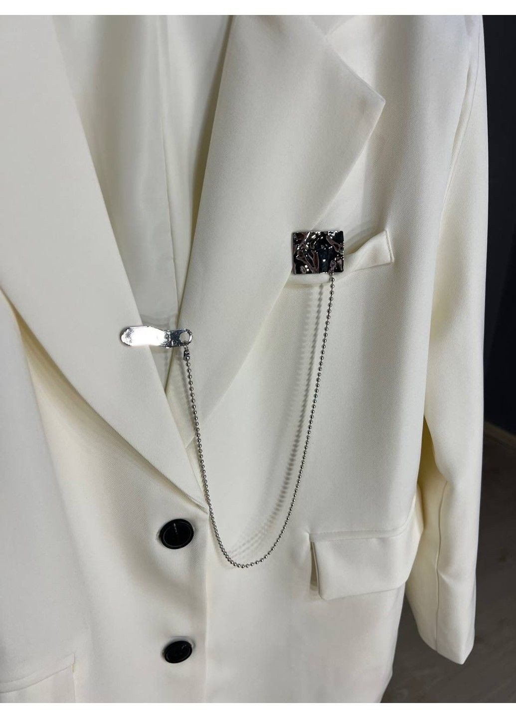 Белый женский пиджак женский qidian 91110 оверсайз широкий крой на пуговицах с аксессуаром цепочкой one size белый No Brand - демисезонный