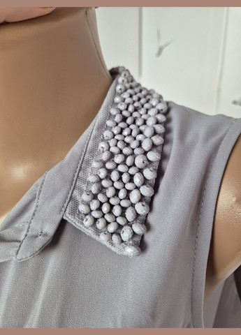 Сіра подовжена жіноча блузка без рукавів однотонна з намистинками на комірі Wallis